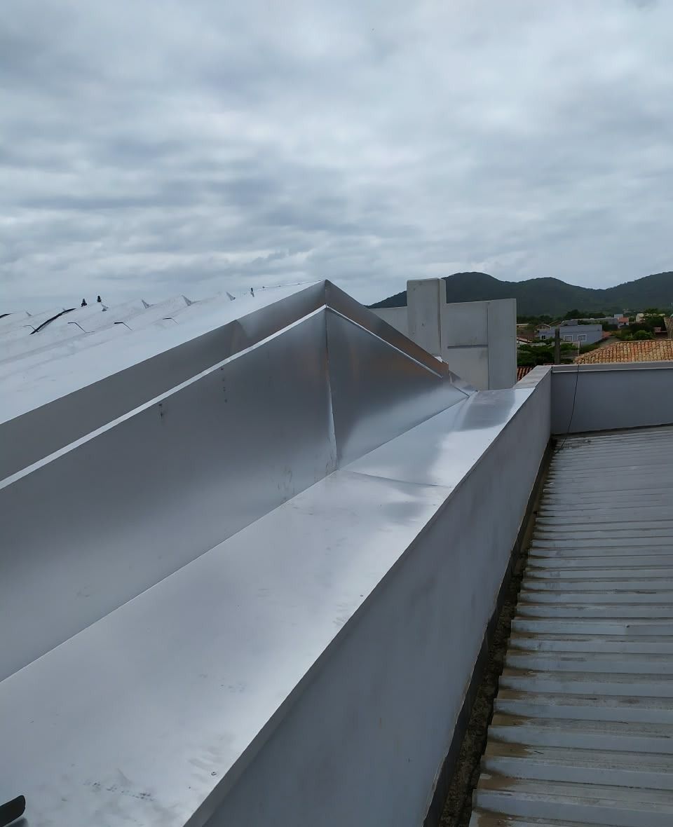 Calha de grande vazão instalada em telhado de galpão industrial em Penha, Santa Catarina